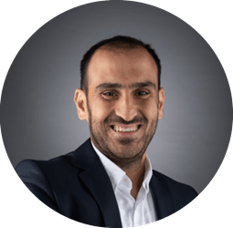 Ali_Aljaani_circle.png a man wearing a suit and tie smiling and looking at the camera