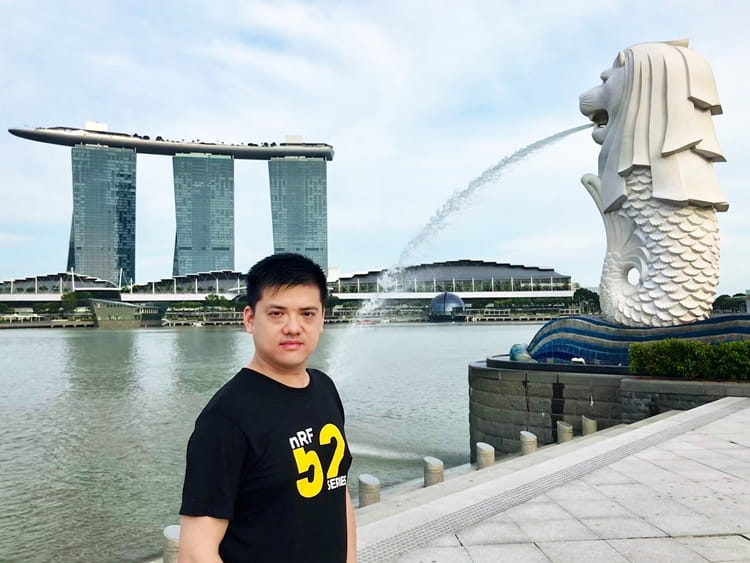 SINGAPORE.jpg a man standing in front of a body of water