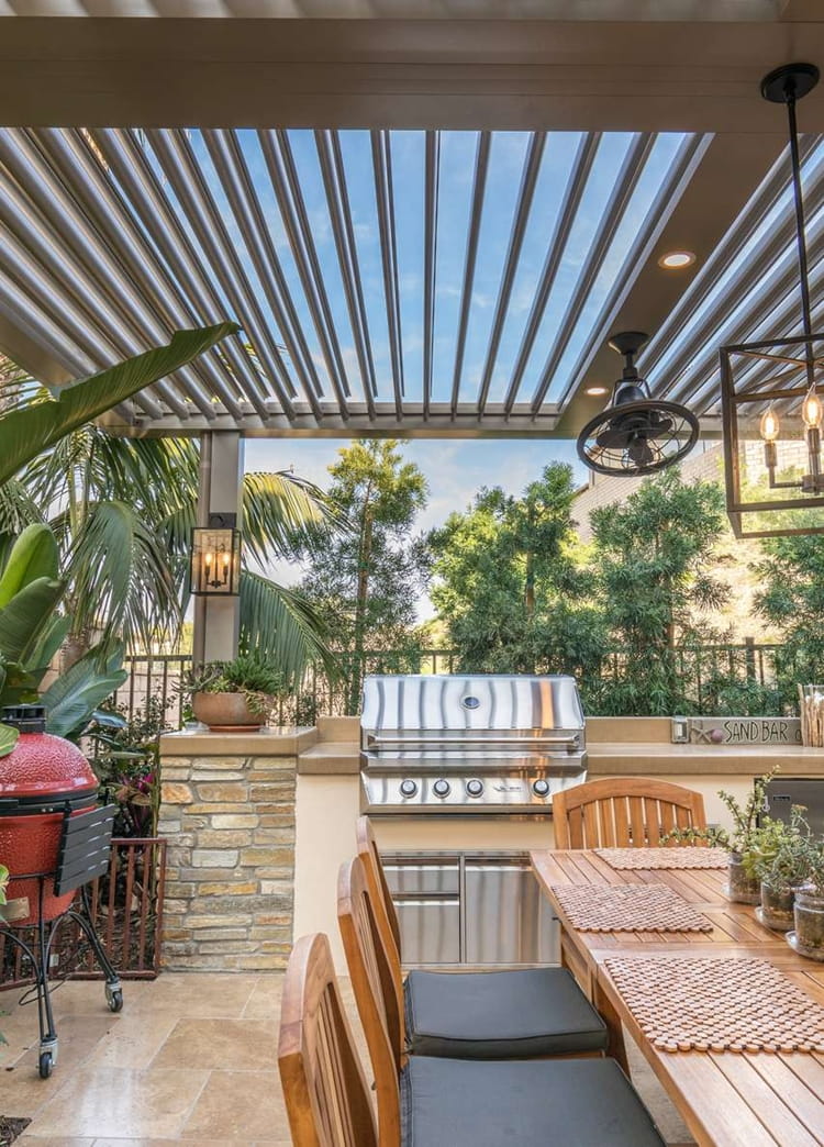 struxure-168385bf-pergola-kitchen_10ny0wy0no0wy00400001o.jpg a room filled with furniture and a fire place sitting in a chair